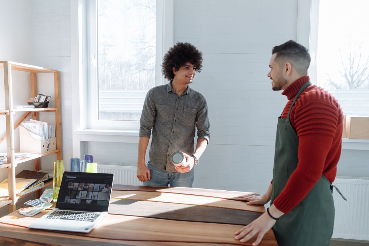 Two people talking in a bright workshop